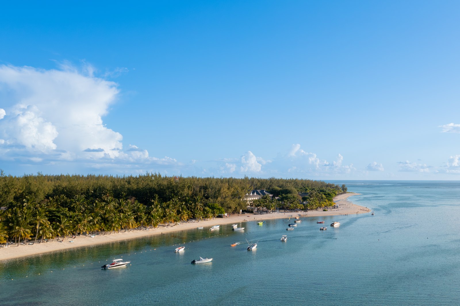 Boats beside a palm-lined beach and calm lagoon at Le Morne, Mauritius